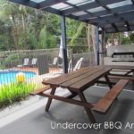 shelly-beach-resort (40) A wooden picnic table under an awning near the pool.