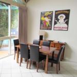 63758280 A dining room table with chairs and posters on the wall.